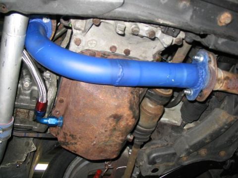 1993 Ford Probe - Close-up of engine bay components including a blue exhaust pipe and oil pan.