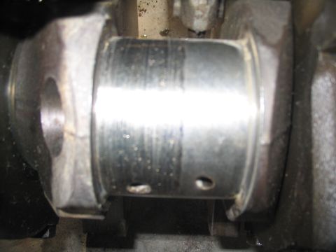 1979 Ford F-150 - Close-up view of a worn engine bearing, showing scoring and oil lubrication holes.