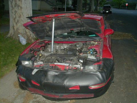 1993 Ford Probe - Front view of a red 1993 Ford Probe with its hood open, revealing the engine bay.