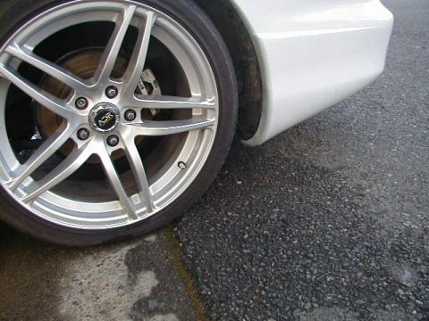 1993 Ford Probe - Aftermarket wheel and fender detail on a white car.