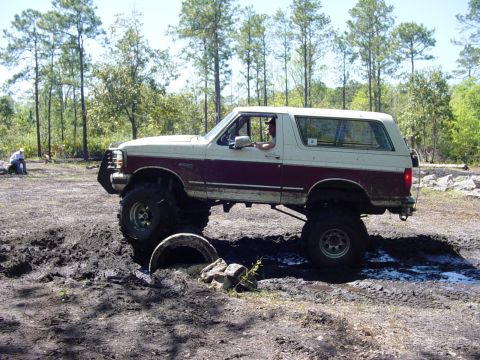 1989 Ford Bronco - This lifted 1989 Ford Bronco tackles a challenging muddy terrain during an off-road event.