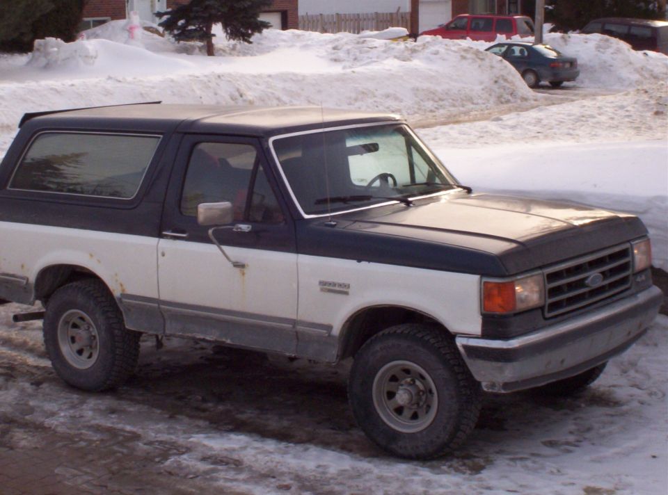 1993 Ford Bronco, two-tone blue and white, parked in snow