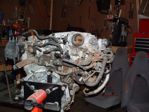 1993 Ford Probe - Engine assembly mounted on an engine stand, with a workshop background and car seats visible.