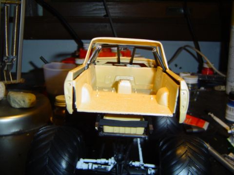 1979 Ford Bronco - A partially assembled model truck is shown from the rear, with its bed and oversized tires in focus.
