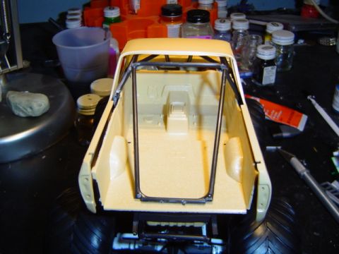 1979 Ford Bronco - Model truck bed with roll cage, unpainted, viewed from rear, surrounded by crafting supplies.