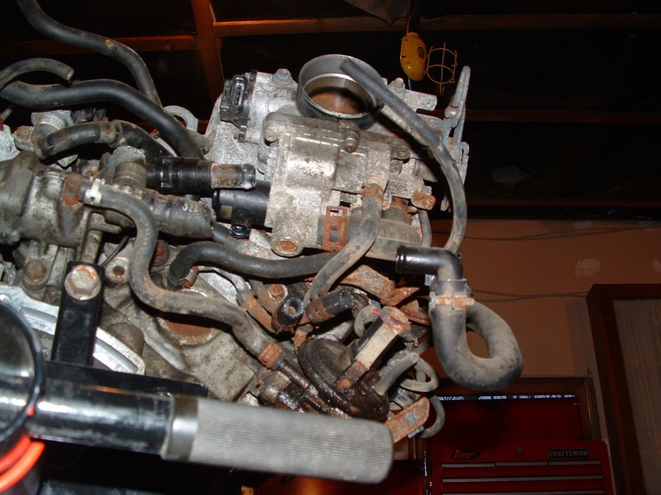 close-up of engine parts with hoses and metal components