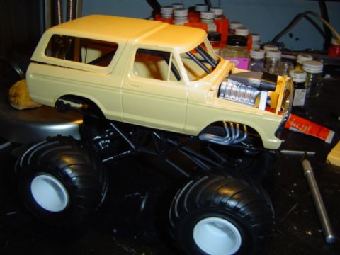 1979 Ford Bronco - A model truck body is mounted on a monster truck chassis, a large chrome engine and exhaust headers.