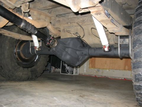1995 Ford Bronco - Close-up view of the rear axle, driveshaft, and suspension components of a vehicle.