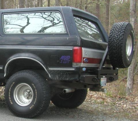 1988 Ford Bronco - This 1988 Ford Bronco features a rear-mounted spare tire and a custom 'MUD SLUT' decal on the side.