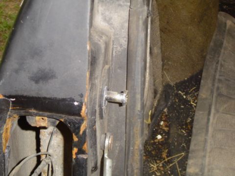 1979 Ford Bronco - Close-up view of a vehicle's door jamb, showing rust and a latch mechanism.