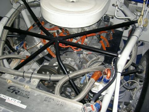 1982 Ford Mustang - Close-up of a race car's engine bay, a V8 engine and intricate plumbing.