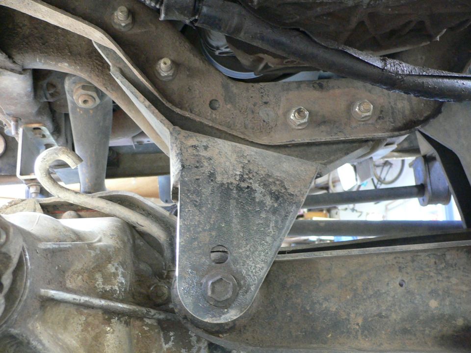 Fabricated steel suspension bracket bolted to truck frame rail underbody