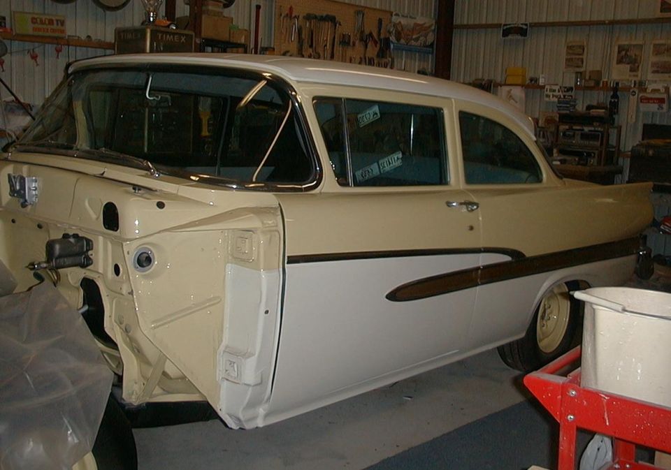 Cream and white 1958 Ford Custom coupe in a garage, front end disassembled during restoration