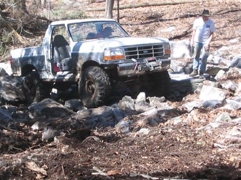 1995 Ford Bronco - This 1995 Ford Bronco is shown off-roading through a rocky, wooded area.