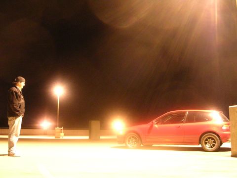 1990 Volkswagen Corrado - A red hatchback is parked on a lot at night, illuminated by streetlights.