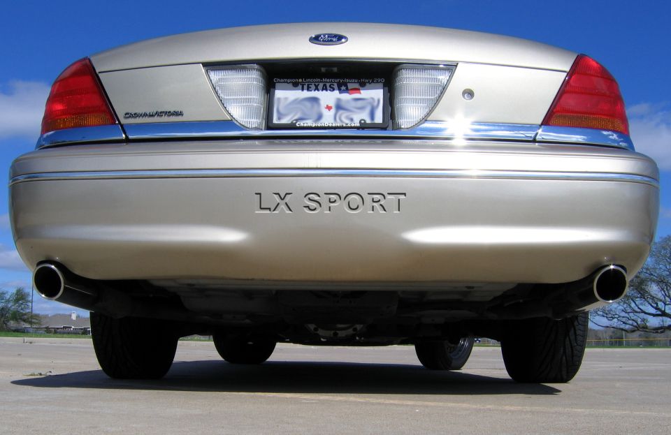 Low straight-on rear view of gold Ford Crown Victoria with LX SPORT bumper lettering and dual tips