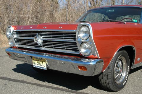 1966 Ford Fairlane - Front view of a red 1966 Ford Fairlane, its distinctive grille and dual headlights. The license plate reads QQ28243.