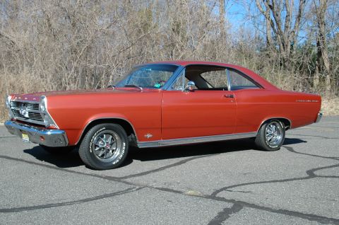 1966 Ford Fairlane - Side view of a 1966 Ford Fairlane coupe with an orange finish and chrome accents.