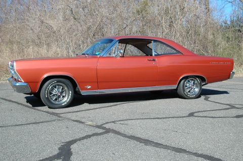 1966 Ford Fairlane - Side profile of an orange 1966 Ford Fairlane coupe parked on asphalt.