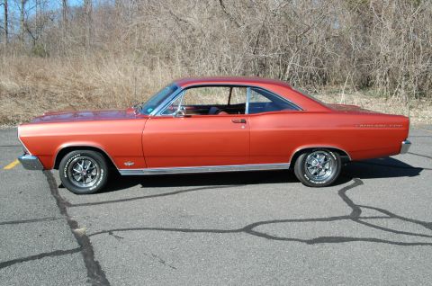 1966 Ford Fairlane - The side profile of an orange 1966 Ford Fairlane 500 coupe shows its classic body lines.
