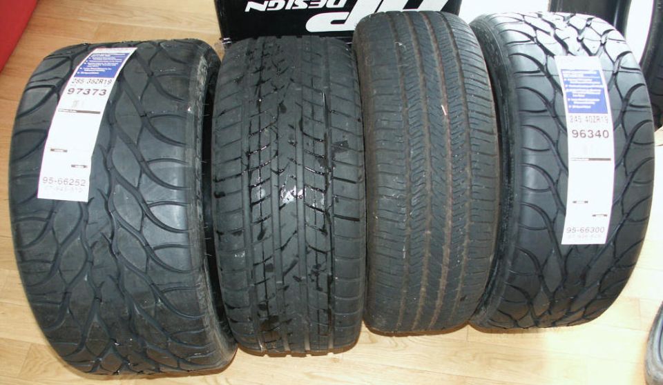 Four tires lined up, two with BFGoodrich labels showing size and part numbers