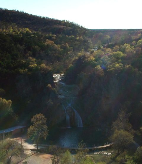 1996 Ford Bronco - A scenic view of a waterfall flowing through a wooded area, with a small structure and pathway nearby.