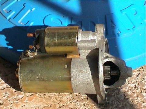 1979 Ford Bronco - A starter motor is shown, its gear mechanism and copper electrical terminals.