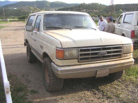 1988 Ford Bronco - This 1988 Ford Bronco is parked outdoors next to another vehicle.