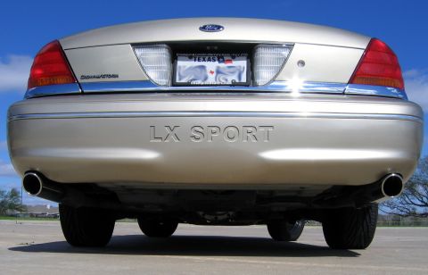 2000 Ford Crown Victoria - The rear of a gold Ford Crown Victoria LX Sport sedan is shown under a clear blue sky.