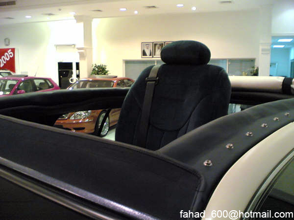 Interior view of a car, showing a seat and a sign that says 2005. Other cars are visible outside