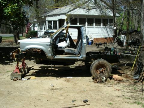 1985 Ford Bronco - This Ford pickup truck is undergoing extensive repairs or modifications, with its body separated from the chassis.