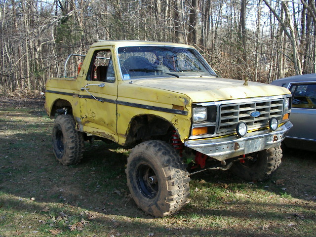 Yellow lifted truck, 3q-front view. Modified for off-road use
