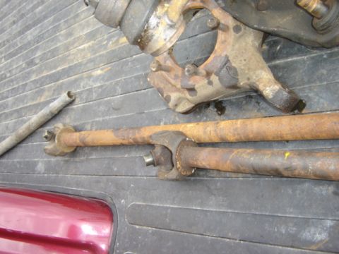 1992 Ford Bronco - Close-up of rusty vehicle axle components resting on a textured surface.