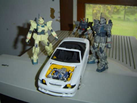1979 Ford Bronco - Model car and robot figures arranged on a surface, with a window in the background.