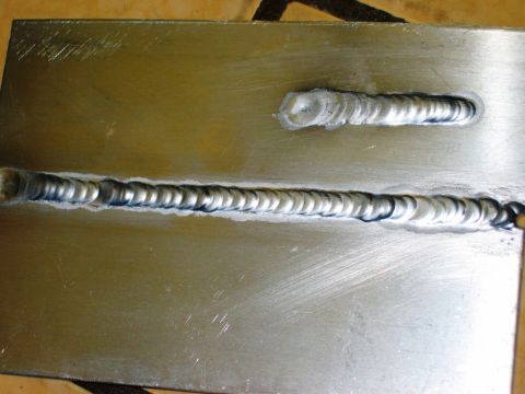 1985 Ford Bronco - Metal plate with two visible welds, one longer than the other, showing the result of a welding process.