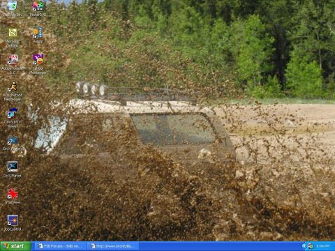 1988 Ford Bronco - A 1988 Ford Bronco navigates a challenging muddy terrain, kicking up a significant amount of mud.