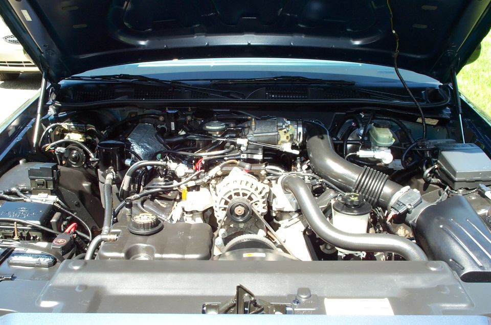 Ford Crown Victoria V8 engine bay with alternator, intake tube, and reservoirs