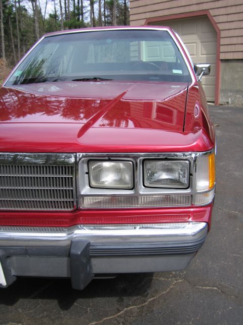 1991 Ford LTD Crown Victoria - Front view of a red sedan, likely from the early 1990s, parked in front of a garage.