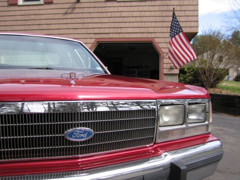 1991 Ford LTD Crown Victoria - Front view of a red 1991 Ford Crown Victoria LTD, its distinctive grille and hood ornament.