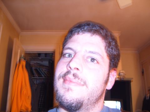 1993 Ford Bronco - A man's face is visible in the foreground, with a closet containing clothes and books in the background.