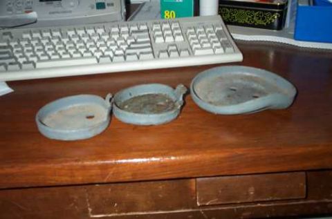 1988 Ford Bronco - Three hubcaps are displayed on a desk, with a keyboard and office supplies in the background.