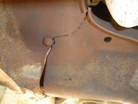 1988 Ford Bronco - Rusted metal frame section with a significant crack and a visible bolt head.