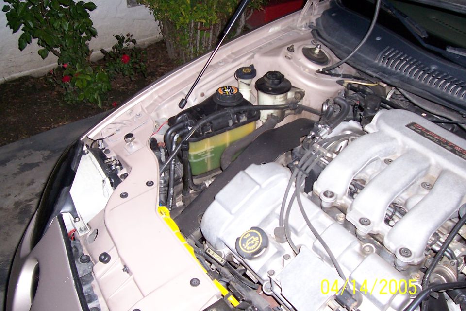 1998 Mercury Sable engine bay, tan exterior, close-up view of engine components and coolant reservoir