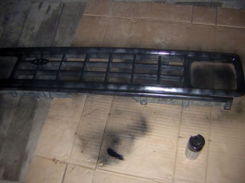 1986 Ford Bronco II - A black grille is shown with a spray paint can and overspray on cardboard.