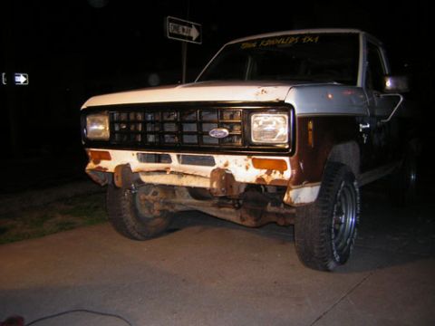 1986 Ford Bronco II - Front view of a 1986 Ford Bronco II with a two-tone paint scheme and visible rust on the bumper.
