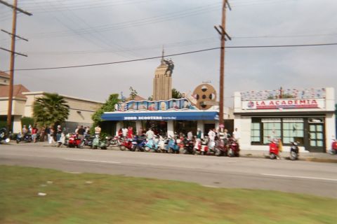1968 Ford Mustang - A large group of scooters are parked in front of a business called 'Nono Scooters'.