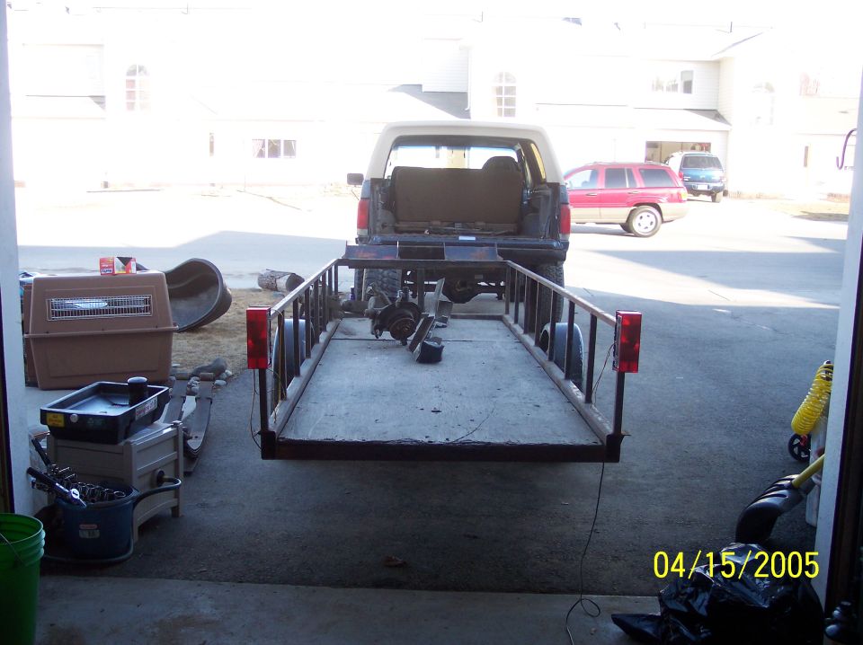 1995 Ford Bronco rear view towing a trailer with parts