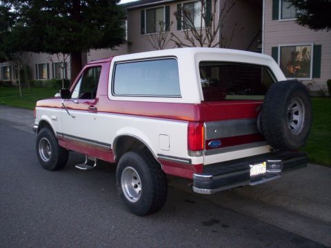 1989 Ford Bronco - Rear view of a two-tone 1989 Ford Bronco with a spare tire on the back.
