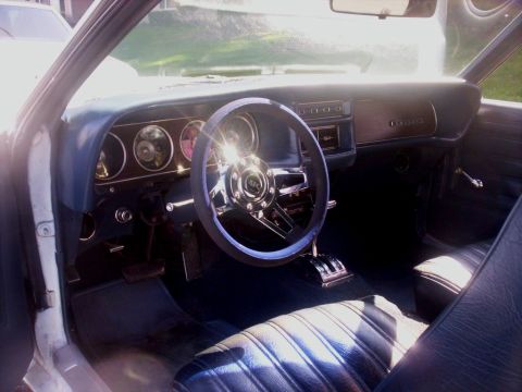 1970 Mercury Cougar - The interior of a 1970 Mercury Cougar shows its distinctive woodgrain dashboard and plush seating.