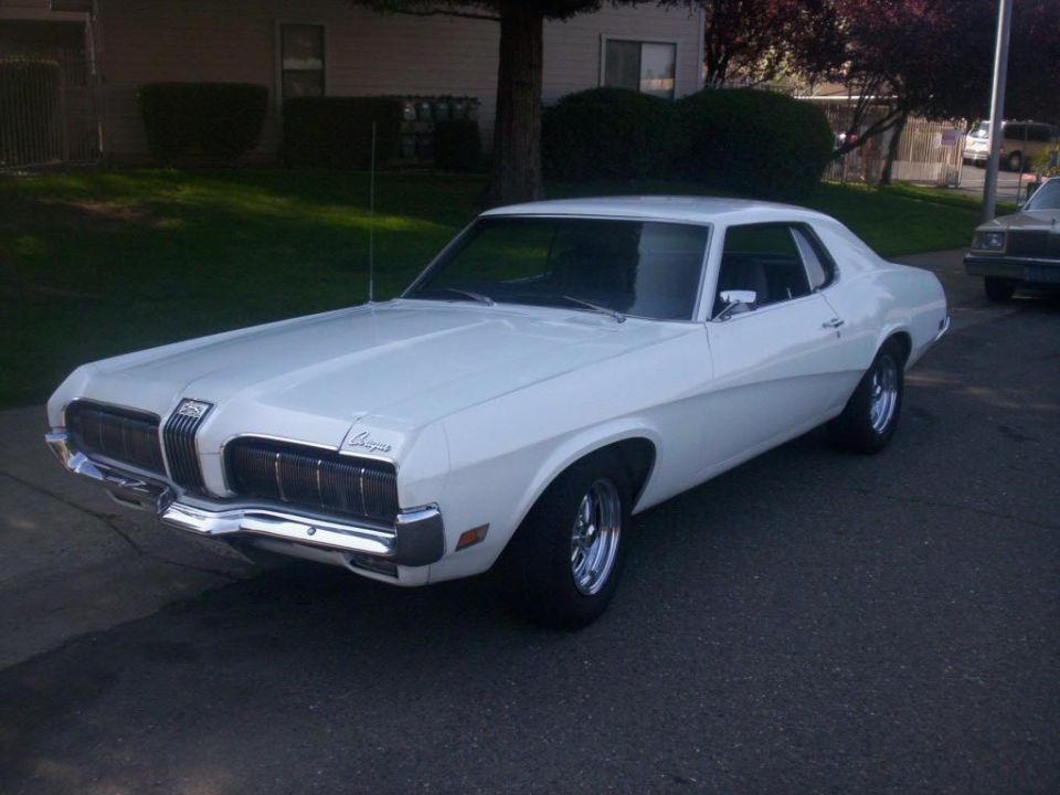 White 1970 Mercury Cougar coupe, front 3/4 view, parked in driveway